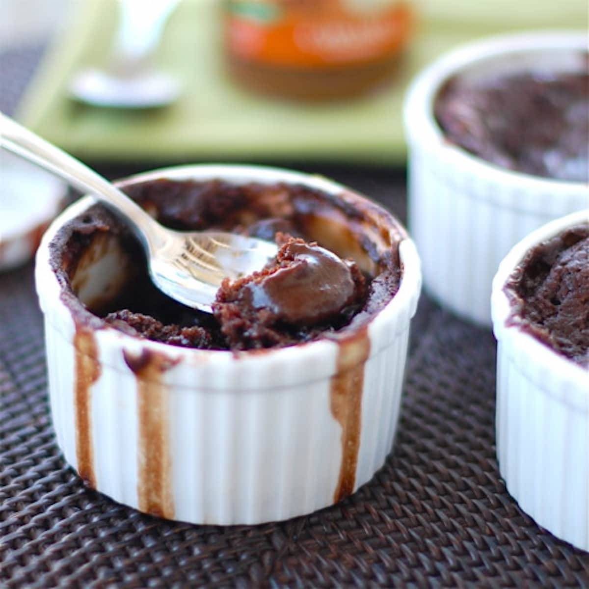 Molten Chocolate cake in a white dish with a spoon.